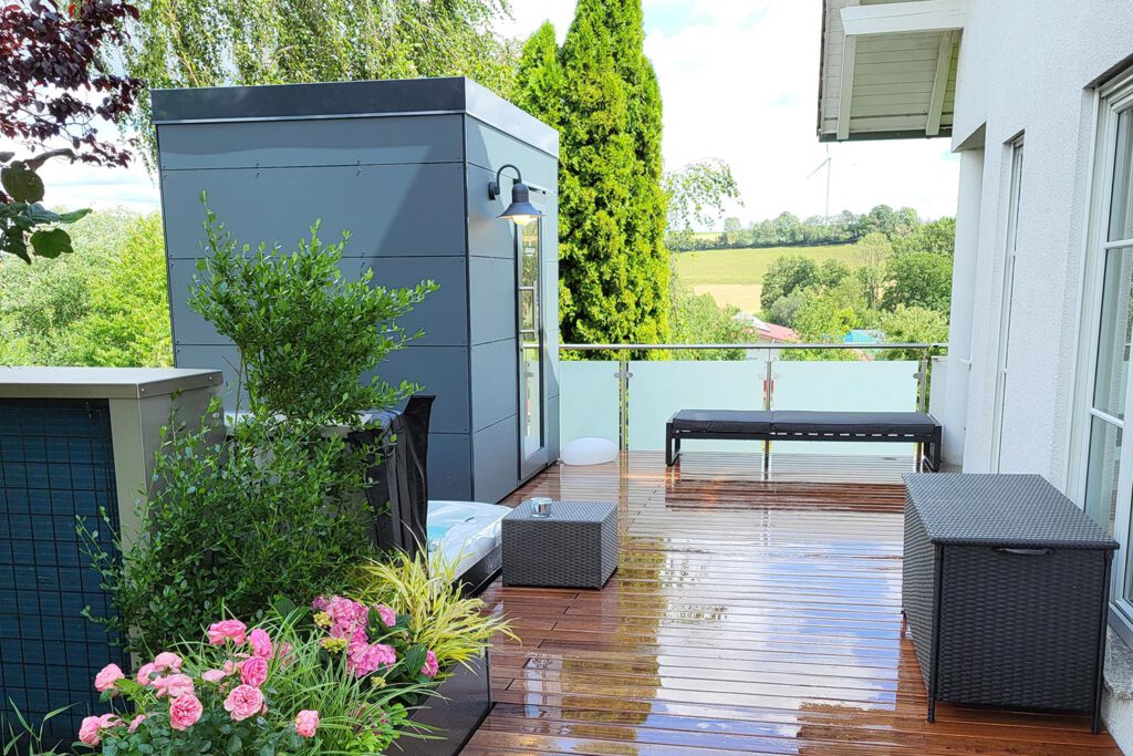 Saunahaus mit grauen Paneelen auf einer Terrasse