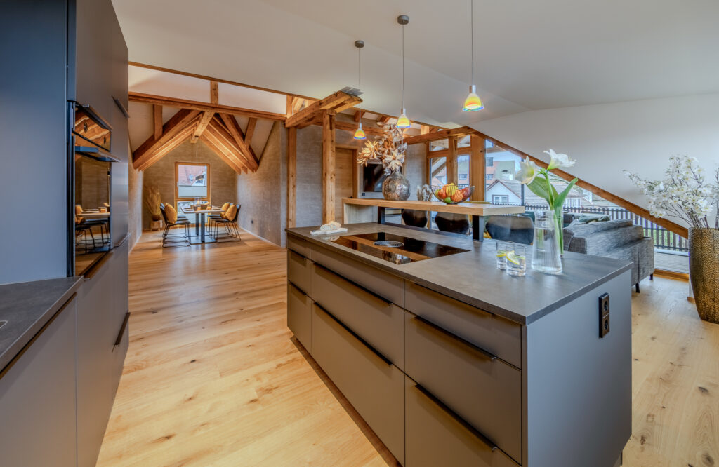 Dunkelgraue moderne Küche in Raum mit Sichtgebälk